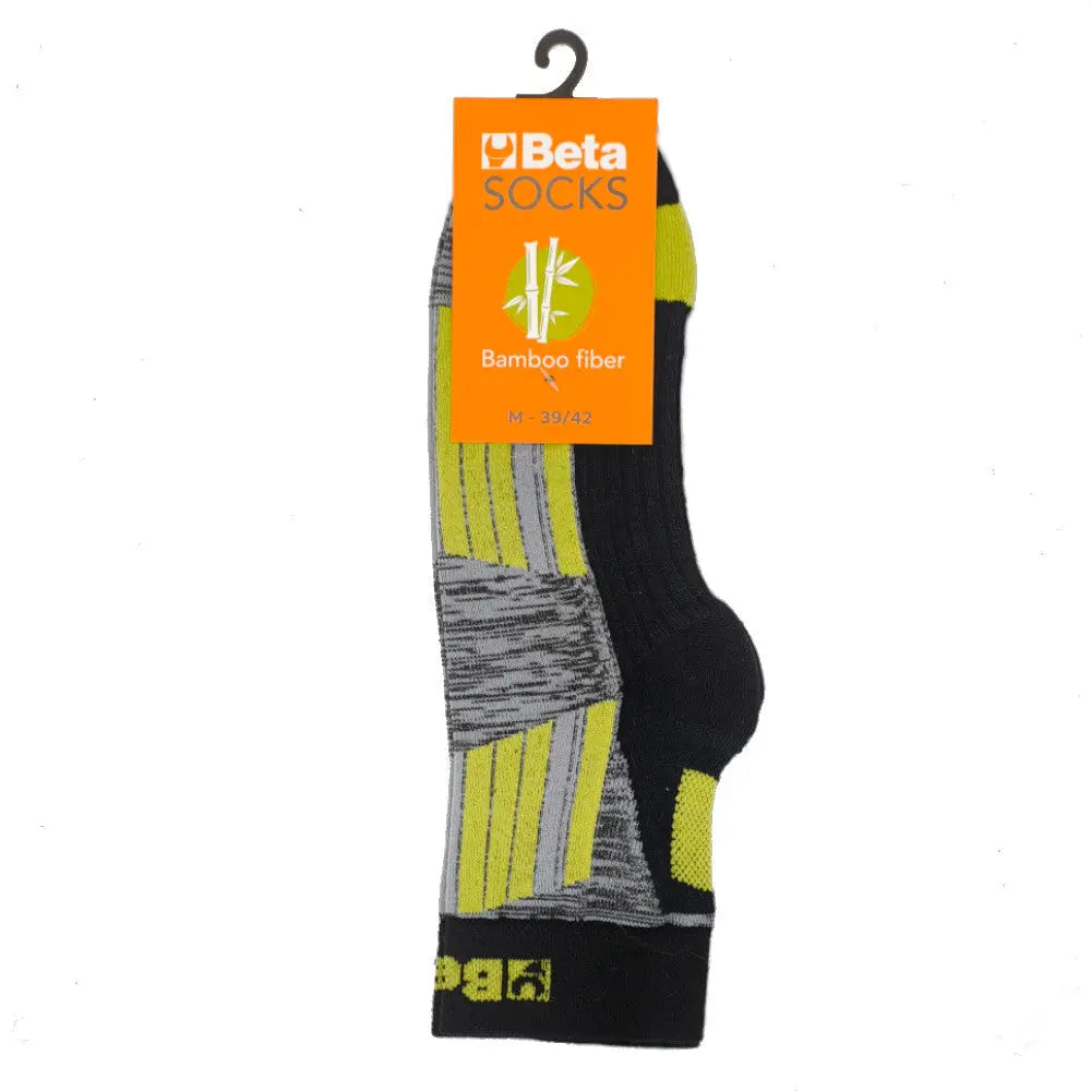 A pair of Beta 7427 socks, crafted from bamboo fiber. The socks are primarily black with stylish gray and neon yellow accents, featuring cushioned soles for comfort. They are showcased with a distinctive bright orange tag on top, which highlights the ‘Beta Socks’ brand name and includes a bamboo leaf graphic. The size M 30-42 is clearly indicated on the tag.